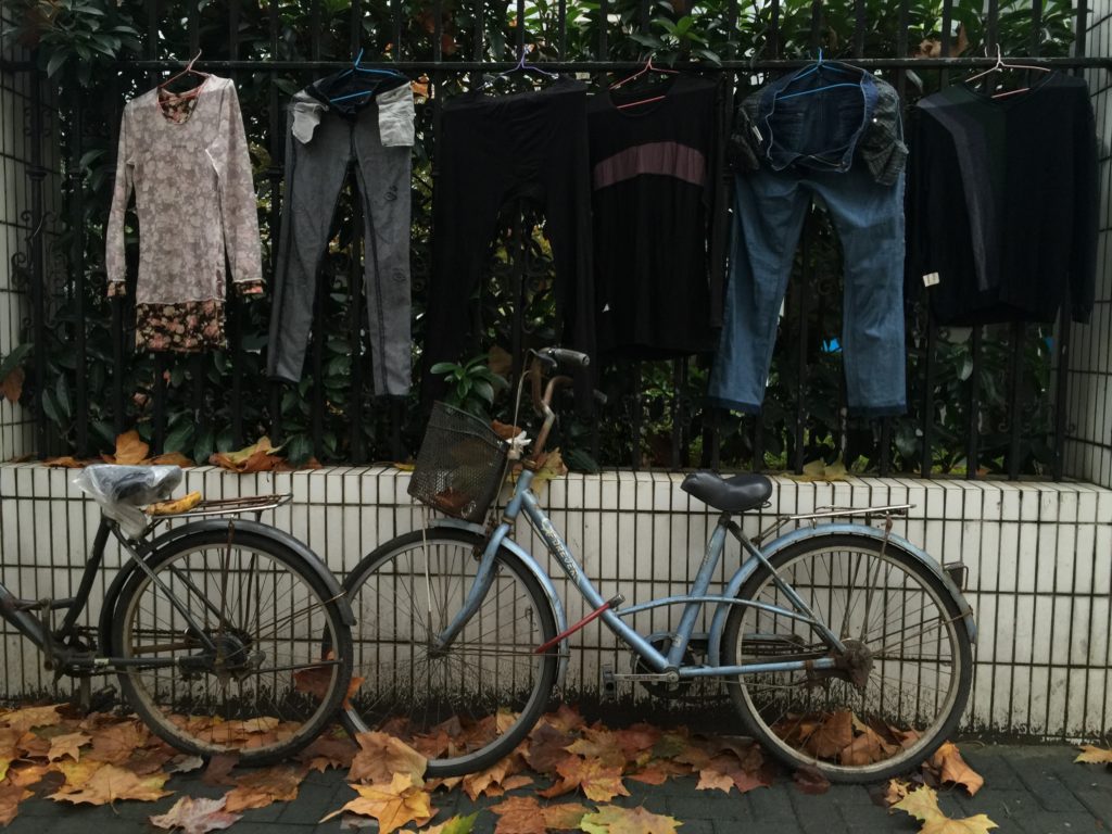 Terrenos na China Roupas penduradas na rua com bicicletas antigas