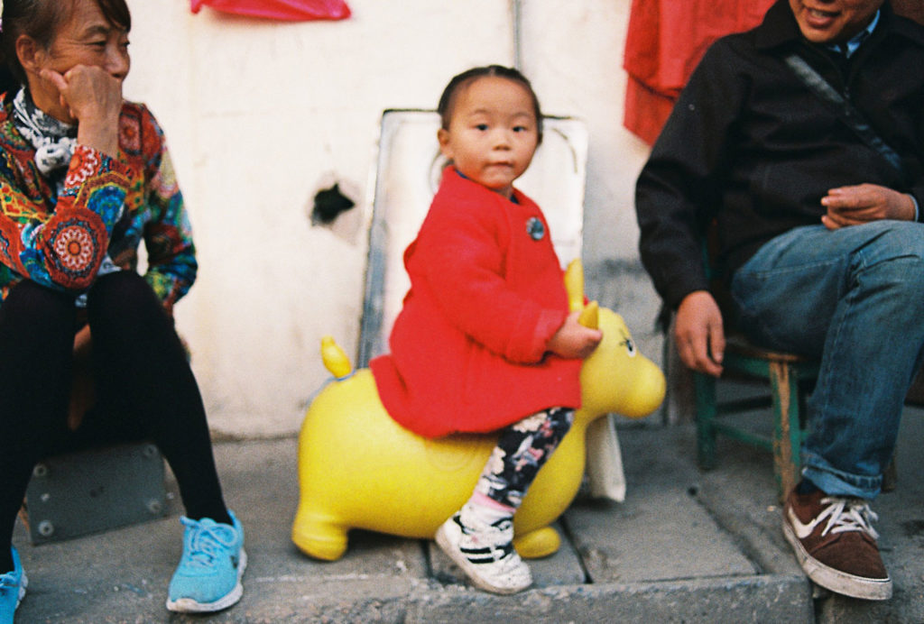Criança brincando em cavalo amarelo
