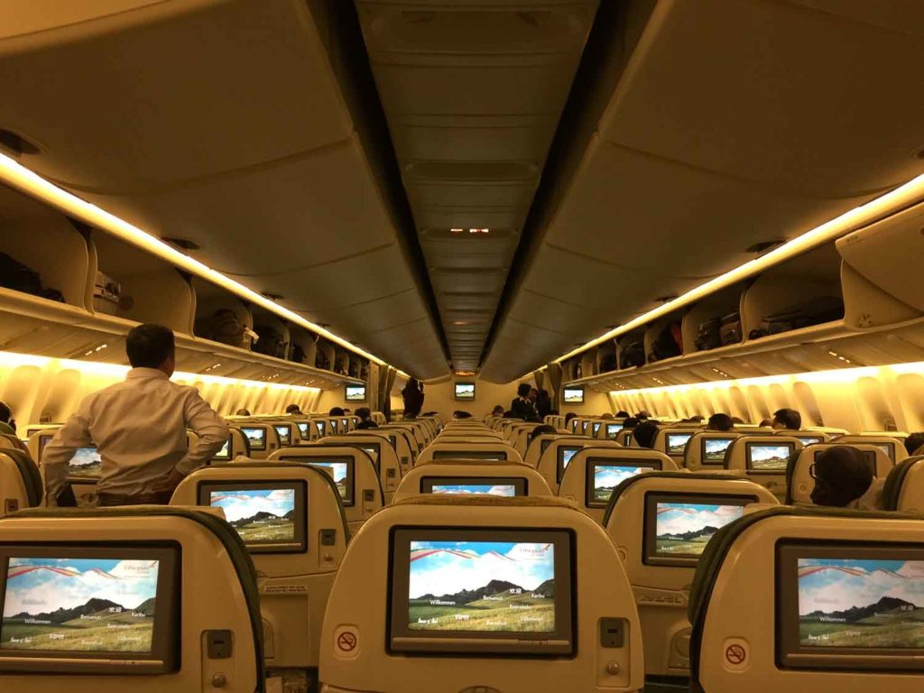 Poltronas do avião com monitores ligado