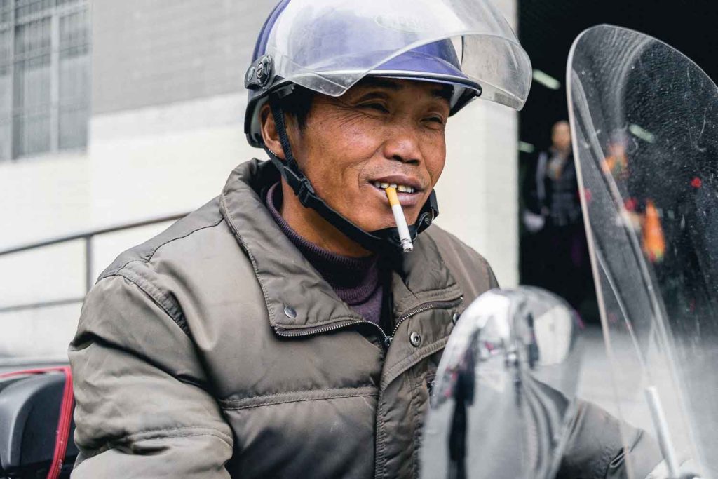 Homem chinese fumando com capacete