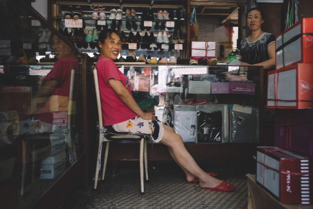 Compras no mercado de Yiwu Mulher sentada em cadeira dentro de loja de sapatos na China