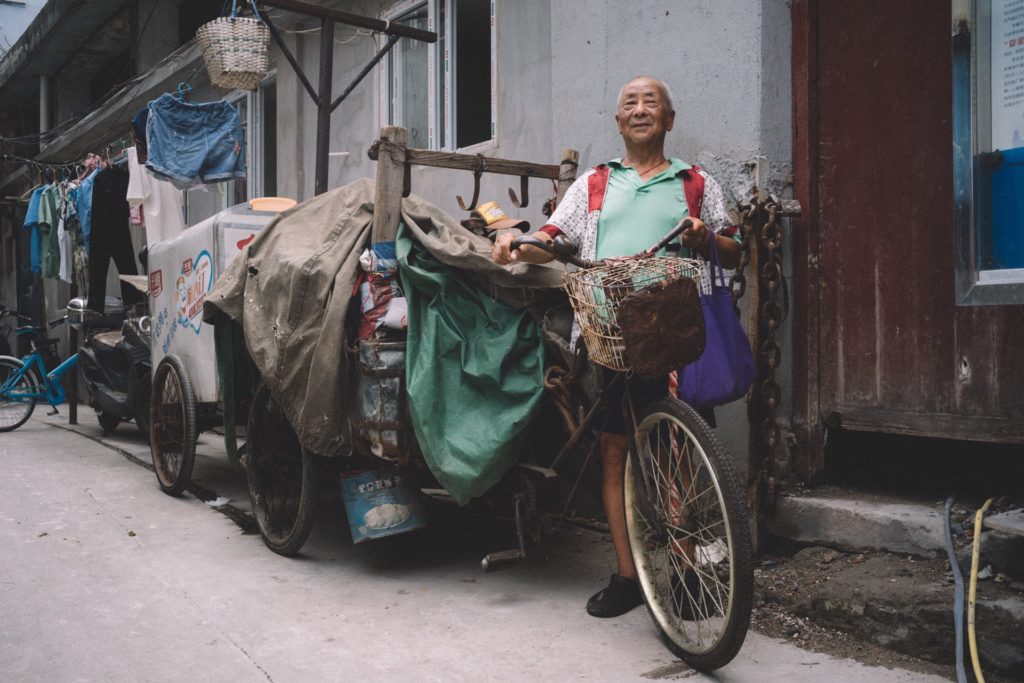 Garantia dos produtos chineses Homem chinês com bicicleta com caixas e panos