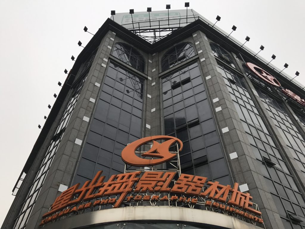 Mercado de câmera fotográfica antiga e nova em Xangai Fachada edifício vidros pretos e letreiro laranja