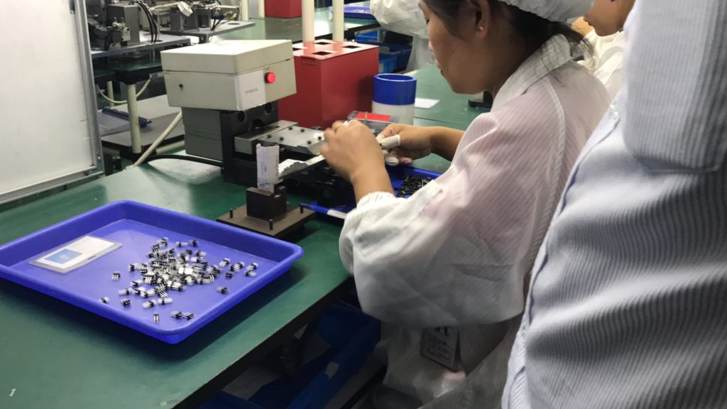Por que a China fabrica o iPhone? Funcionária trabalhando em fábrica na China