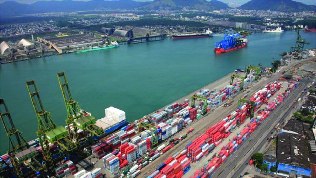 Uma vista aérea de um grande porto de contentores com implicações no comércio internacional.