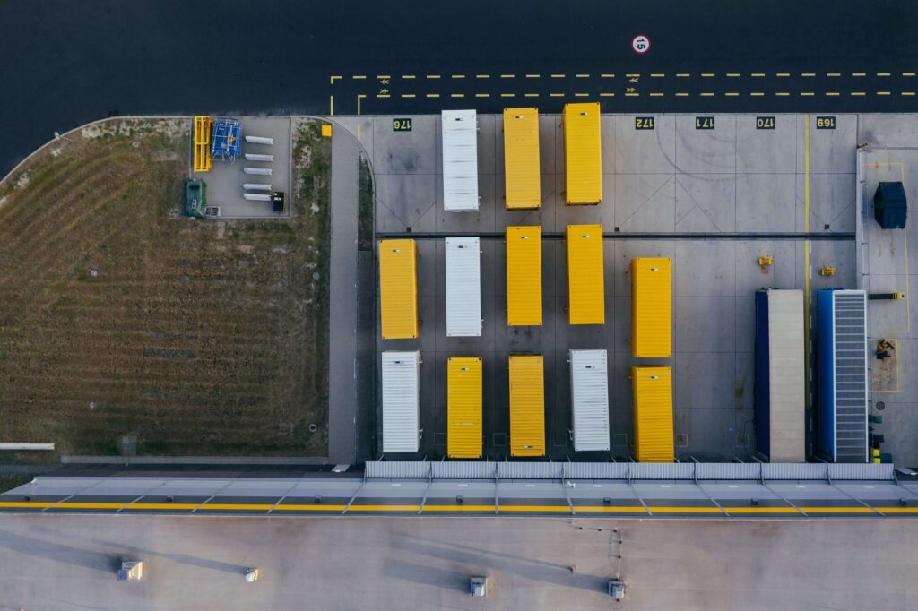 Vista aérea de um caminhão amarelo estacionado em um estacionamento mostrando tendências e previsões para as perspectivas de importação no Brasil em 2023.