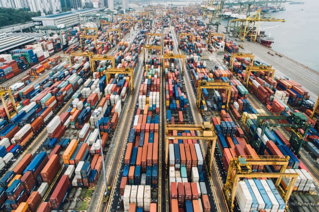 Uma vista aérea de um porto de contêineres em Hong Kong, mostrando o movimentado centro de comércio marítimo.