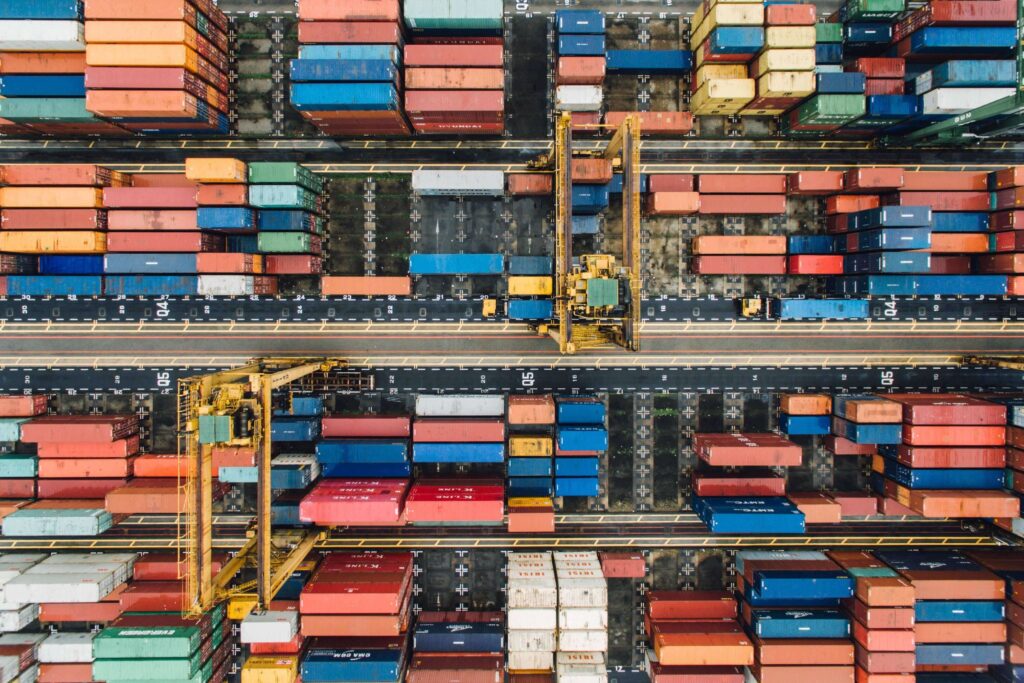 Uma vista aérea de contêineres em um pátio de contêineres, mostrando a organização e armazenamento eficiente de mercadorias.