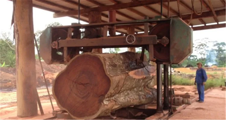 Um homem opera uma máquina de cortar madeira.