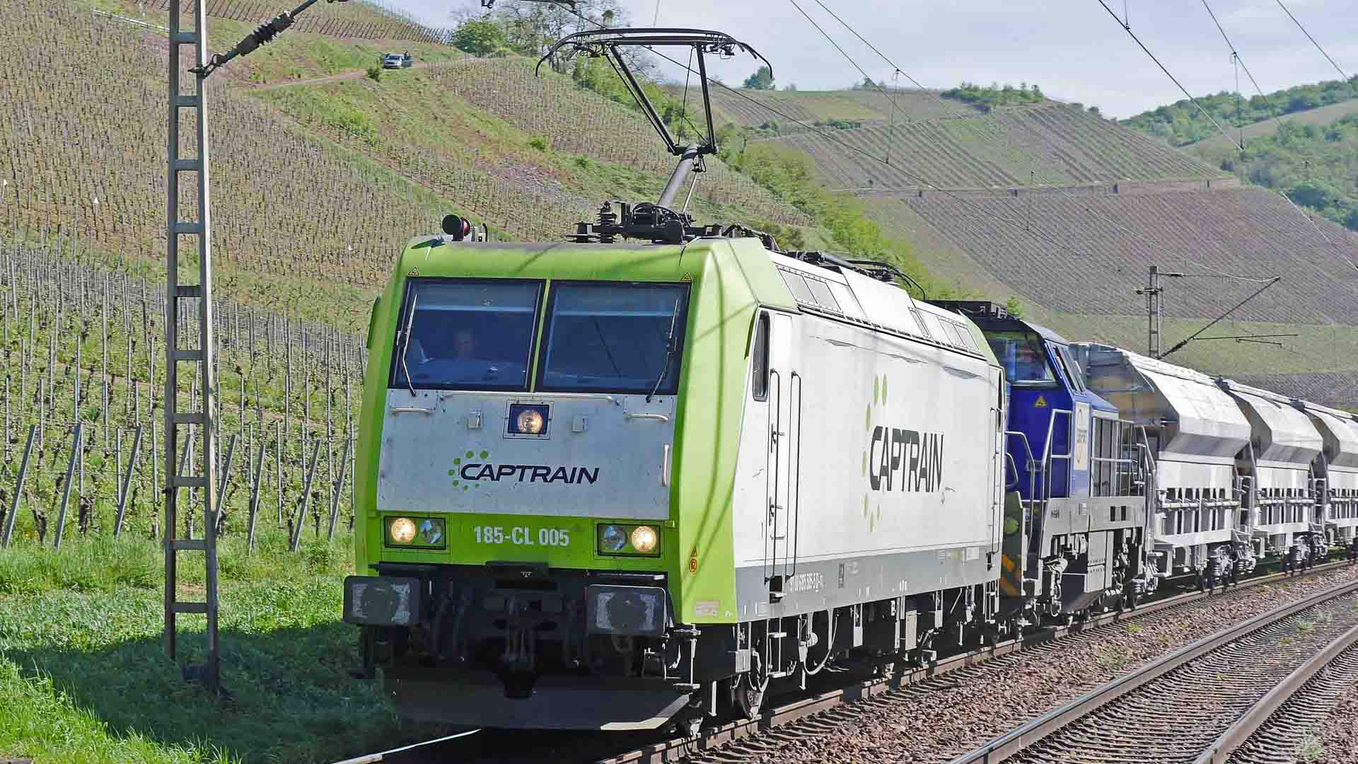 A locomotiva Captrain verde e branca puxa um trem de carga pela paisagem dos vinhedos, deslizando por baixo de fios elétricos. Observar sua jornada parece tão tranquilo quanto navegar regulamentações de importação enquanto garante que seu negócio funcione sem problemas.