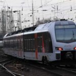 Um trem de passageiros atravessa uma complexa rede de trilhos sob fios aéreos, lembrando as movimentadas rotas onde alguém poderia considerar se importar um iPhone para o Brasil realmente vale a pena.