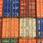 Contêineres de transporte coloridos empilhados com vários logotipos de empresas e números de identificação estão prontos para exportação, exibindo a melhor forma de organização. Perfeito para aqueles que buscam pesquisar na China de forma eficiente.