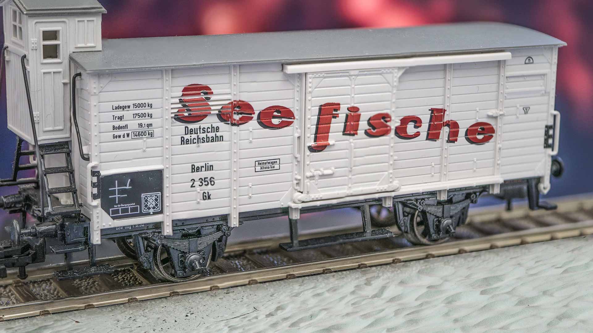 Vagão modelo de trem com design branco e vermelho de 2024 com texto "Seefische", marcações ferroviárias alemãs e detalhes complexos, disponível na coleção Produtos Importados.