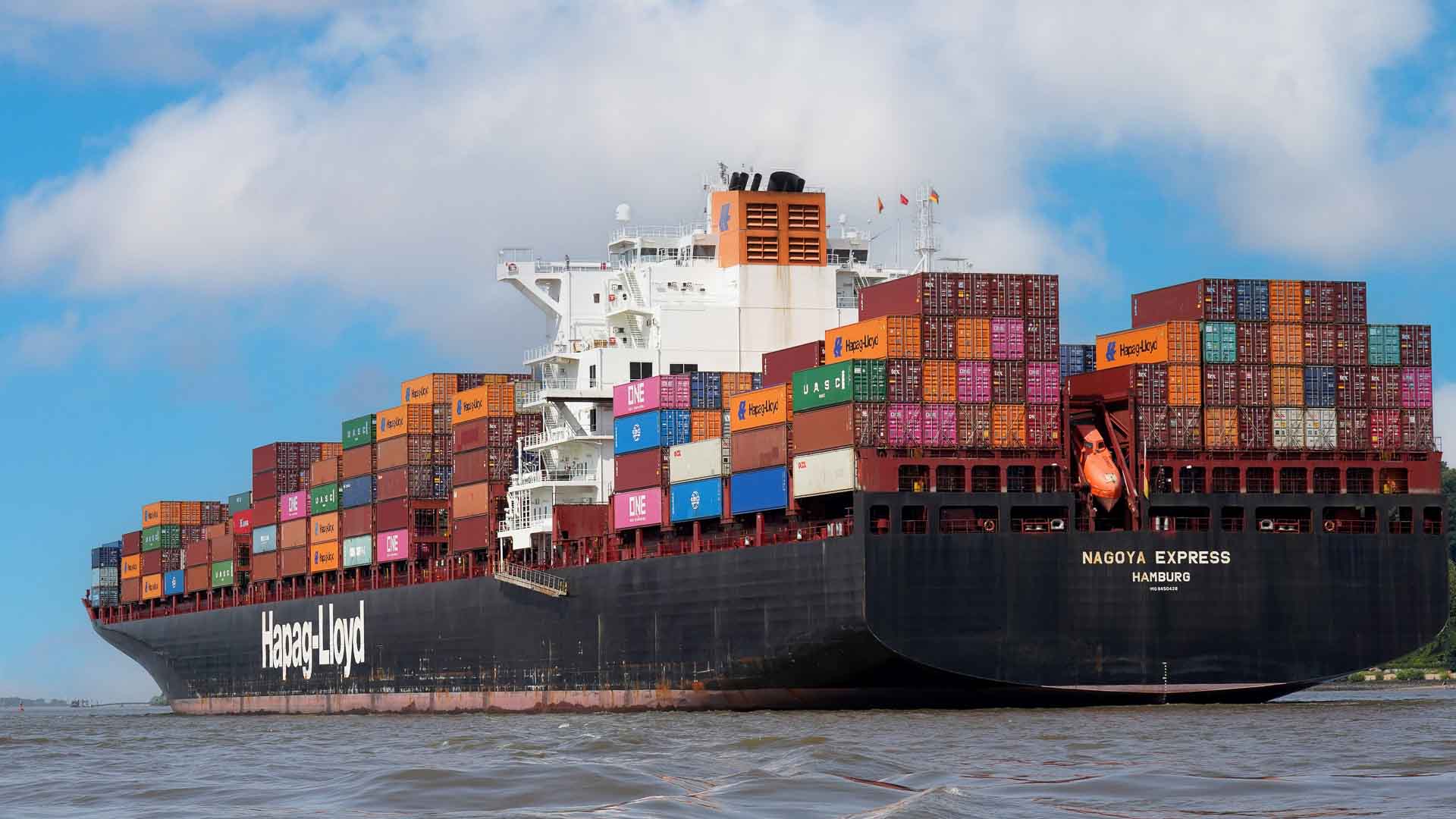 Um grande navio de carga, carregado com Produtos da China, navega sob um céu parcialmente nublado, com seu convés abarrotado de contêineres coloridos que prometem qualidade.