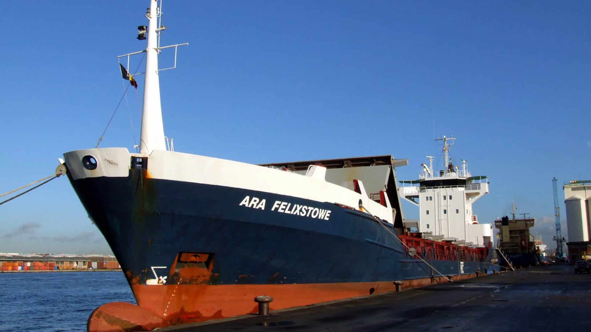 O grande navio de carga chamado ARA Felixstowe, que deve revolucionar os transportes da China em 2024, atracou em um porto sob um céu azul claro.