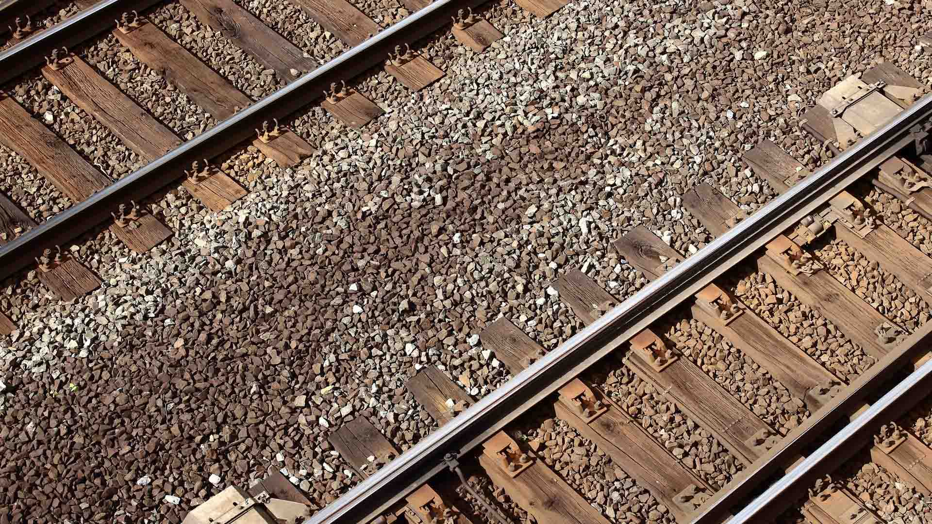 Vista de perto de trilhos ferroviários paralelos com cascalho e dormentes de madeira, uma cena que lembra as movimentadas rotas que levam a Yiwu, um importante mercado na China.
