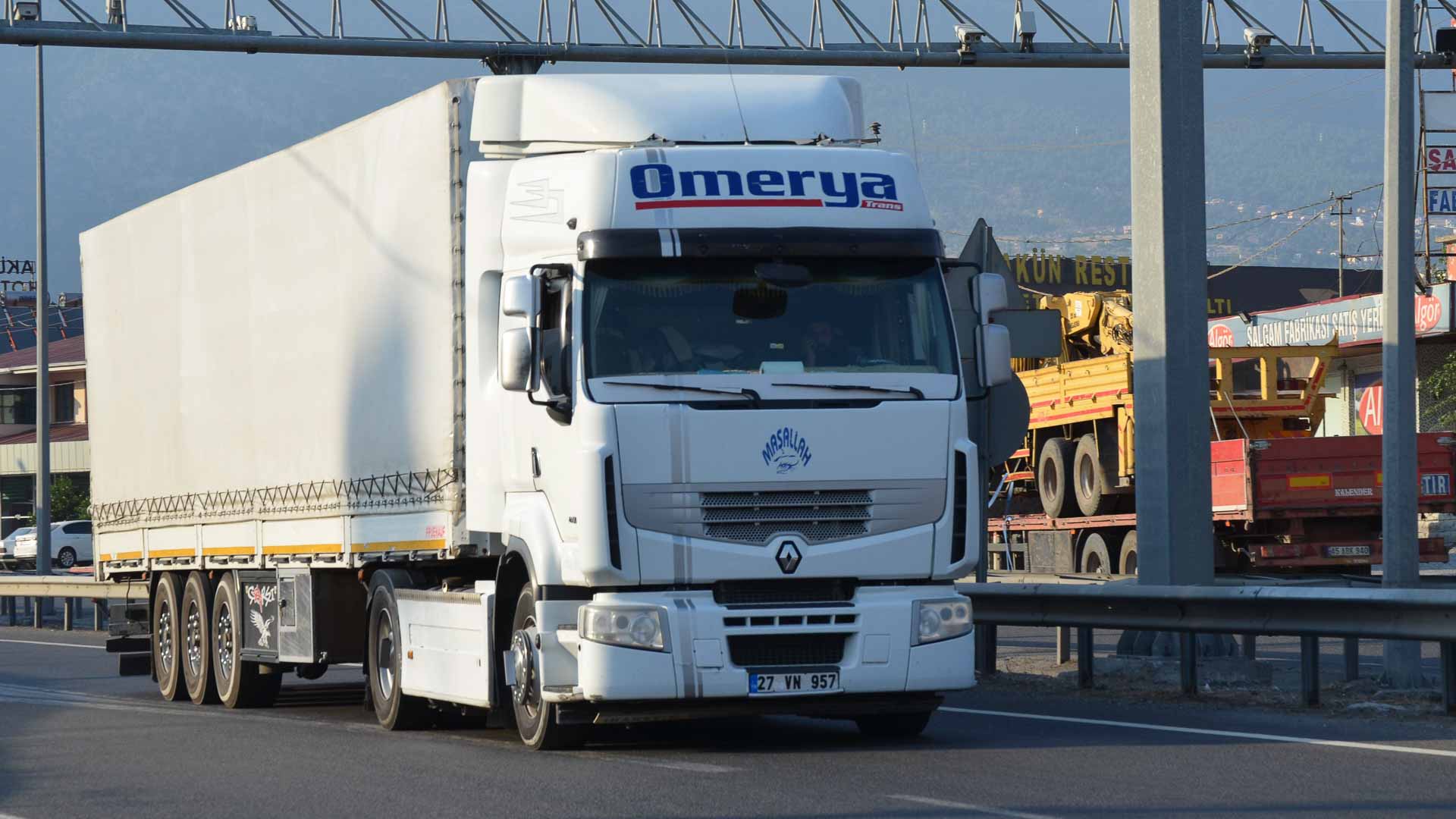 Um caminhão branco Renault com reboque coberto trafega em uma rodovia, simbolizando o caminho para o sucesso da importação até 2025.